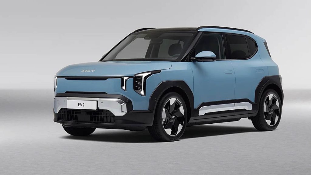 El mercado europeo del coche eléctrico continúa ampliando su oferta hacia segmentos cada vez más accesibles, y Kia quiere posicionarse con fuerza en esa transición. La marca coreana ha presentado oficialmente el nuevo EV2, un SUV compacto totalmente eléctrico que se convierte en el modelo de acceso a su gama de vehículos de cero emisiones. Tras su estreno mundial en el Salón del Automóvil de Bruselas de 2026, el modelo ya tiene precio en Europa y ha comenzado a aceptarse pedidos en algunos mercados, con una tarifa de partida de 26.600 euros en Alemania. El EV2 se convierte en el sexto modelo eléctrico desarrollado específicamente por Kia dentro de su estrategia global de electrificación, y al mismo tiempo en el más pequeño de la familia EV. Su papel dentro de la gama es claro: servir como puerta de entrada a la movilidad eléctrica de la marca, atrayendo tanto a nuevos compradores como a conductores que se estrenan en el coche eléctrico. La compañía lo plantea como un vehículo compacto pensado para la vida urbana, pero con suficiente espacio y autonomía como para desempeñar también el papel de coche principal en muchos hogares. Con 4,06 metros de longitud, 1,80 metros de anchura y 1,575 metros de altura, el EV2 se sitúa en el competitivo segmento de los B-SUV eléctricos, uno de los nichos que más crecimiento está experimentando en Europa. La distancia entre ejes alcanza los 2.565 milímetros, una cifra relativamente generosa para su tamaño exterior y que explica parte del enfoque de Kia en maximizar el espacio interior. En términos de diseño, la marca ha aplicado su filosofía estética Opposites United, que ya se ha visto en otros eléctricos recientes de la compañía. El resultado es un SUV compacto con una presencia robusta, pasos de rueda marcados y una silueta relativamente vertical que busca reforzar la sensación de solidez. El frontal adopta superficies limpias y elementos de iluminación verticales con el patrón Star Map característico de la marca, mientras que los laterales muestran unos voladizos muy cortos y líneas rectas que ayudan a optimizar el espacio en el habitáculo. En la parte trasera, los pilotos se sitúan en los extremos de la carrocería para enfatizar visualmente la anchura del vehículo. La gama incluirá también una variante GT-Line que refuerza el carácter visual del modelo con paragolpes específicos, elementos exteriores diferenciados y llantas de mayor tamaño. Esta versión busca ofrecer una imagen más dinámica dentro de un modelo que, en esencia, sigue priorizando la practicidad y el uso cotidiano. Uno de los aspectos en los que Kia ha puesto más énfasis es el interior. A pesar de ser el modelo eléctrico más compacto de la gama, la marca ha tratado de crear un habitáculo con personalidad propia. El diseño se inspira en la idea de una “caja de picnic”, un concepto que describe un espacio personal acogedor pensado para ofrecer un momento de calma dentro del ritmo urbano. La disposición del salpicadero está dominada por una pantalla panorámica compuesta por tres elementos: una instrumentación digital de 12,3 pulgadas, una pantalla central de infoentretenimiento también de 12,3 pulgadas y un módulo dedicado al climatizador de alrededor de cinco pulgadas. La arquitectura horizontal del interior busca ampliar visualmente la sensación de espacio, mientras que los controles físicos se mantienen para las funciones más utilizadas con el objetivo de facilitar su manejo durante la conducción. El vehículo incorpora además iluminación ambiental que puede sincronizarse con los intermitentes, aportando tanto un elemento estético como una ayuda visual adicional. La configuración interior también destaca por su flexibilidad. El EV2 se ofrecerá con dos disposiciones distintas. La primera es una configuración convencional de cinco plazas con un maletero de 362 litros. La segunda plantea un enfoque más modular con cuatro plazas y asientos traseros independientes, deslizantes y reclinables, que permiten aumentar el volumen de carga hasta 403 litros cuando se adelantan completamente. A esto se añade un pequeño compartimento delantero o frunk de aproximadamente 15 litros bajo el capó. Kia ha incorporado además numerosas soluciones de almacenamiento y confort pensadas para el uso cotidiano. Entre ellas se encuentran una consola central flexible, portavasos ajustables, una bandeja de carga inalámbrica para smartphones y puertos USB-C capaces de ofrecer hasta 100 W de potencia para alimentar dispositivos electrónicos. El sistema multimedia incluye audio premium firmado por Harman/Kardon y funciones digitales personalizables. El equipamiento tecnológico también se apoya en funciones cada vez más habituales en los vehículos eléctricos modernos. El EV2 incorpora actualizaciones inalámbricas OTA, llave digital y un asistente de inteligencia artificial diseñado para interactuar con el conductor mediante comandos conversacionales. Incluso introduce pequeños detalles pensados para reforzar la experiencia de usuario, como mensajes de bienvenida en la pantalla al entrar en el coche o despedidas al finalizar el trayecto. En el apartado técnico, el nuevo modelo utiliza la conocida plataforma eléctrica E-GMP del grupo Hyundai, en este caso en su configuración de 400 voltios. El EV2 estará disponible con dos opciones de batería. La versión de acceso emplea un paquete de 42,2 kWh que ofrece una autonomía homologada de 317 kilómetros según el ciclo WLTP. Por encima se sitúa una batería de 61 kWh que eleva el alcance hasta 453 kilómetros WLTP, una cifra destacable dentro de su tamaño. La recarga rápida permite pasar del 10 al 80 % en aproximadamente 29 o 30 minutos dependiendo de la versión elegida. En corriente continua puede alcanzar hasta 118 kW de potencia, mientras que en corriente alterna admite carga de 11 kW de serie o hasta 22 kW de forma opcional a partir de determinados niveles de equipamiento. Según Kia, el EV2 será el primer modelo de la marca en ofrecer esa capacidad de carga de 22 kW en CA. El vehículo también incorpora funciones avanzadas para facilitar la experiencia eléctrica, como planificador de rutas específico para vehículos eléctricos, sistema Plug & Charge para simplificar el proceso de recarga en estaciones compatibles y capacidades de carga bidireccional V2L y V2G que permiten alimentar dispositivos externos o devolver energía a la red. En materia de seguridad y asistencia a la conducción, el pequeño SUV eléctrico integra un amplio conjunto de sistemas heredados de modelos superiores de la marca. Entre ellos se encuentran el asistente de prevención de colisiones frontales FCA 2.0, el asistente de mantenimiento de carril, el control de crucero inteligente, el asistente de conducción en autopista HDA 2 o el asistente de aparcamiento remoto. También incorpora monitorización de ángulo muerto, advertencias de tráfico cruzado trasero y sistemas de visión periférica para facilitar las maniobras. Uno de los elementos que más interés ha despertado tras su presentación ha sido su posicionamiento en precio. En Alemania, el Kia EV2 arranca en 26.600 euros en la versión Light equipada con la batería de 42,2 kWh. La gama se organiza en cuatro niveles de acabado: Light, Air, Earth y GT-Line. Incluso el modelo de acceso incluye elementos como faros LED, climatizador automático, la pantalla panorámica y un amplio conjunto de asistentes de conducción. Con este precio de partida, el modelo se sitúa en una franja muy competitiva dentro del mercado eléctrico europeo. De hecho, su tarifa inicial es inferior a la de algunos utilitarios eléctricos del segmento B. Un ejemplo es el Renault 5 eléctrico en su versión de autonomía urbana, que en Alemania parte de unos 28.000 euros. La estrategia de Kia consiste precisamente en acercar el precio de los SUV eléctricos a niveles comparables a los de los utilitarios eléctricos tradicionales. Otro aspecto importante dentro del planteamiento del modelo es su producción. El EV2 se fabricará en la planta que Kia posee en Žilina, Eslovaquia, una instalación clave para la compañía en el mercado europeo. Allí también se producirá el EV4 para el mercado del continente. Según el calendario previsto, las primeras entregas a clientes comenzarán en abril de 2026 con las versiones Air y Earth equipadas con la batería estándar. Las variantes con batería de mayor capacidad llegarán a partir de julio, mientras que la versión de acceso Light está prevista para octubre. El vehículo contará con la garantía habitual de Kia de siete años, además de una garantía específica para la batería de ocho años o 160.000 kilómetros y un programa de asistencia en carretera. Durante el mismo evento en Bruselas, Kia también aprovechó para ampliar su estrategia de electrificación con nuevas versiones de alto rendimiento. La marca presentó los EV3 GT, EV4 Hatchback GT y EV5 GT, modelos que incorporarán tracción total con doble motor, suspensión controlada electrónicamente y modos de conducción específicos diseñados para ofrecer una experiencia más deportiva. Estas versiones forman parte de la evolución de la filosofía GT de la marca, que ya se había materializado en modelos eléctricos como el EV6 GT o el EV9 GT. La llegada del EV2 refleja una tendencia cada vez más evidente dentro de la industria del automóvil. A medida que la tecnología madura y los costes comienzan a reducirse, los fabricantes están trasladando la electrificación hacia segmentos más compactos y asequibles, especialmente en Europa, donde los coches urbanos y utilitarios siguen representando una parte muy importante del mercado. En ese contexto, un modelo como el EV2 reúne varios elementos clave: producción europea, un precio de acceso relativamente contenido, autonomías que superan los 450 kilómetros en su versión más capaz y una dotación tecnológica comparable a la de vehículos de segmentos superiores. Si consigue mantener ese equilibrio entre coste, autonomía y practicidad, el pequeño SUV de Kia podría convertirse en una de las propuestas más relevantes dentro de la nueva generación de eléctricos compactos que aspiran a acercar definitivamente el coche eléctrico al gran público europeo.